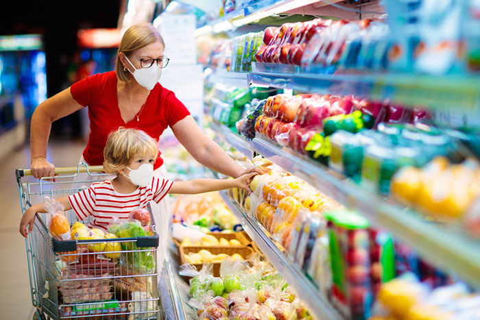 family wearing a face mask in a grocery aisle